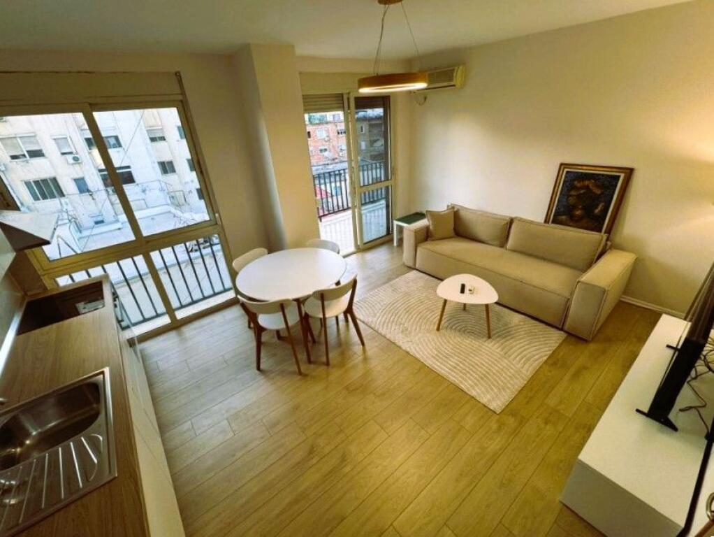 **Apartament 1+1 me qira** në një **pallat të ri** në zonën e **Rrugës së Kavajës / 21 Dhjetori**,
